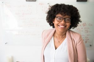 A happy woman smiling in front of a white board